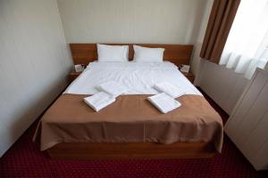 a bedroom with a large bed with two towels on it at Népliget Hotel in Budapest