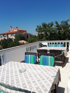 un patio con mesas y sillas en el balcón en Apartments Miljak en Fažana