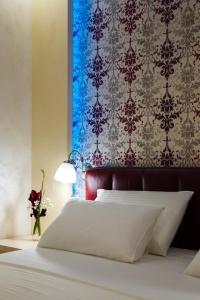 a bedroom with a white bed and a blue wall at Apartman Boska Lux in Subotica