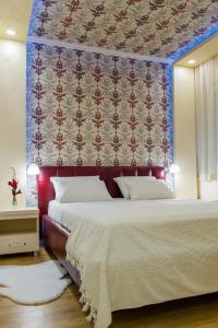 a bedroom with a large bed with a red wall at Apartman Boska Lux in Subotica