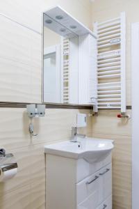 a white bathroom with a sink and a mirror at Apartman Boska Lux in Subotica +35 photos