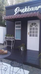 a purple building with a white door and a bench at Dankbaar in Bloemfontein