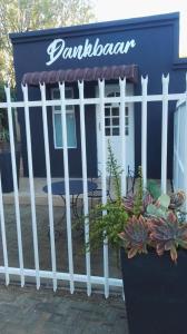 a white fence in front of a blue building at Dankbaar in Bloemfontein +6 photos