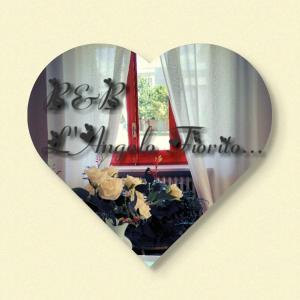 a heart shaped window with a reflection of a window with flowers at B&B L'angolo fiorito in Bernalda