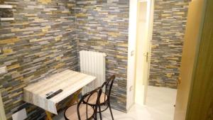 a table and chairs in a room with a brick wall at Vera Vacanza in Sannicola