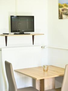 a table with a computer monitor on a shelf at Lüggerts in Ennigerloh