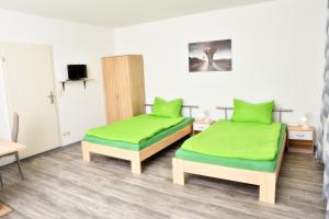 a room with two beds with green cushions at Lüggerts in Ennigerloh