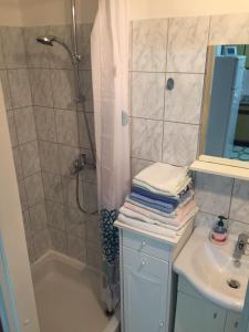 een badkamer met een douche, een wastafel en een bad bij Apartment Subota in Mali Lošinj