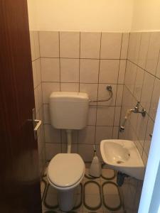 a small bathroom with a toilet and a sink at Apartment Subota in Mali Lošinj