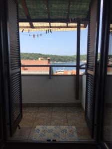 an open door to a room with a view of a roof at Apartment Subota in Mali Lošinj