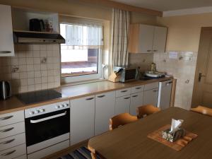 a kitchen with a table and a stove and a window at Ferienhaus Bergfrieden in Sankt Leonhard im Pitztal