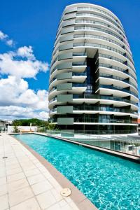 a large building with a swimming pool in front of it at Ambience on Burleigh Beach in Gold Coast