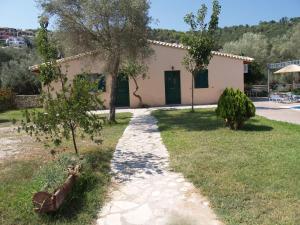 a house with a pathway leading to a yard at Rania Studios in Lefkada