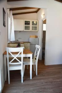 cocina con mesa y 2 sillas blancas en Levantara en Jezera
