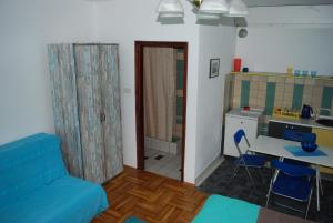 a living room with a blue couch and a kitchen at Guest House Ozon in Soko Banja