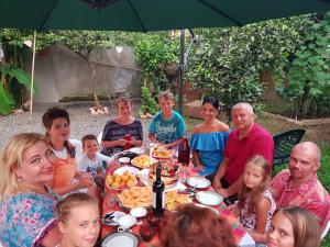 a group of people sitting around a table with food at Apartment MaxinJauri in Makhinjauri