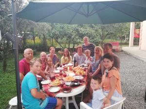 a group of people sitting at a table eating food at Apartment MaxinJauri in Makhinjauri