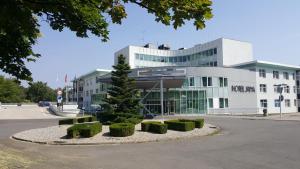 un edificio con un árbol delante de él en Hotel Jana, en Přerov