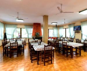- une salle à manger avec des tables, des chaises et des fenêtres dans l'établissement Lago Resort, à Nuévalos