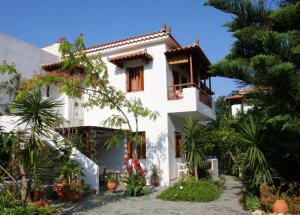 a white house with plants in front of it at Katikies Stamatias Studios & Maisonettes in Agnontas