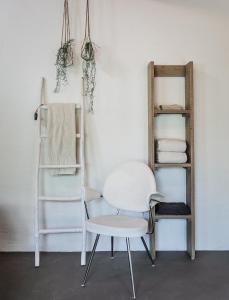 a white chair and a shelf in a room at LAAREIND Bed & Breakfast in Waalre