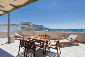 eine Terrasse mit einem Tisch und Stühlen sowie Meerblick in der Unterkunft Belvedere Luxury Apartments & Spa in Plakias