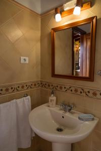 y baño con lavabo, espejo y toallas. en Country house Santa Lucia en Puntallana