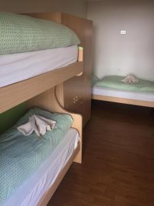 sypialnia z 2 łóżkami piętrowymi i ręcznikami na podłodze w obiekcie Appartamenti Gosetti - CIPAT 022114-AT-060137 w mieście Mezzana