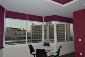 a room with a table and chairs and large windows at Diamond Torremolinos in Torremolinos