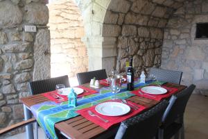 einen Tisch mit Tellern und Gläsern sowie eine Flasche Wein in der Unterkunft Villa Bartola in Grižane + 60 Fotos