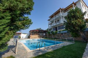 a house with a swimming pool in front of a building at Villa Mara in Panormos Skopelos