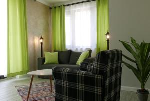 uma sala de estar com um sofá, uma mesa e cortinas verdes em Shahbazian House em Plovdiv