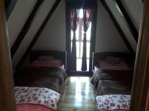 a attic room with four beds and a window at House SUN Z&B in Žabljak