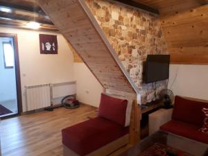 a living room with a staircase with a stone wall at House SUN Z&B in Žabljak