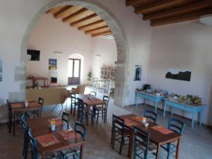 a restaurant with wooden tables and chairs in a room at Le Sorelle del Vino in Marzamemi