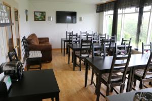 a room with tables and chairs and a couch at Dettifoss Guesthouse in Skinnastadur
