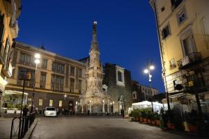 a building with a tower in the middle of a street at Madì Rooms in Naples