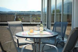 a table with a bottle of wine and two glasses at Ferienwohnungen Gritzner in Tröpolach