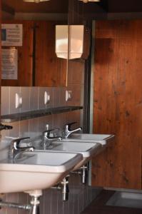 y baño con lavabo blanco y espejo. en Albergue Rural Las Águedas, en Murias de Rechivaldo