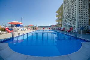 a large pool with blue water in front of a building at Landmark Motel in Wildwood