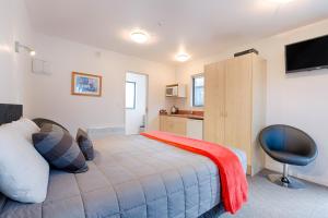 a bedroom with a bed and a desk and a chair at Bella Vista Motel Te Anau in Te Anau