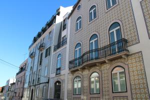 um grande edifício de tijolos com varandas numa rua em Estrela Penthouse - Amazing Views em Lisboa