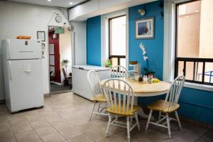 a kitchen with a table and chairs and a refrigerator at Saint Lawrence Residences and Suites in Toronto