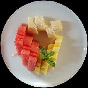 a white plate with a bunch of different types of fruit at Buda Cottage Ubud in Ubud