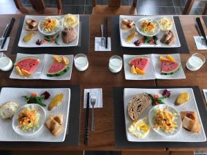 a wooden table with plates of food on it at Bi La Homestay in Luye