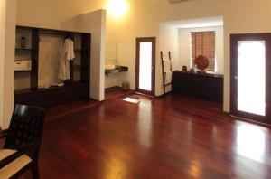 a living room with a hard wood floor and two doors at Kebun Villas & Resort in Senggigi