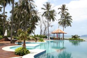a swimming pool with palm trees and a gazebo at NATAYA Round House Coral Bay Resort in Kampot