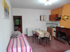 a kitchen with a table and chairs and a fireplace at DEPARTAMENTOS YAPAY PEÑI in Plottier