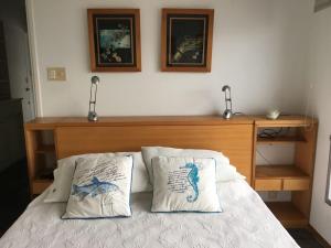 um quarto com uma cama com duas almofadas em Departamento Vista al Mar em Punta del Este