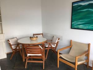 a table and chairs in a room with a painting at Departamento Vista al Mar in Punta del Este